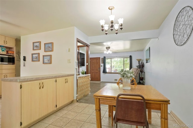 dining room featuring ceiling fan with notable chandelier and light tile patterned floors