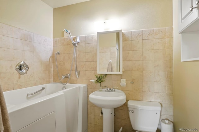 full bath featuring toilet, a bathing tub, and tile walls