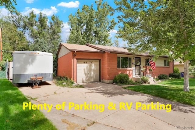 view of front of property with an attached garage, driveway, a front yard, and brick siding