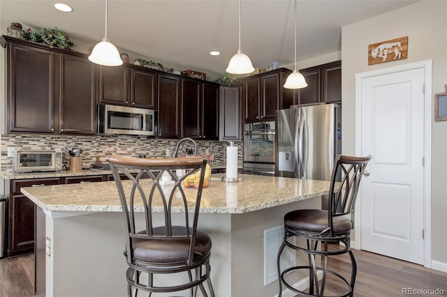 24351 E Alamo Dr, Aurora, CO 80016 - kitchen featuring stainless steel appliances, dark wood-style floors, dark brown cabinetry, backsplash, and recessed lighting