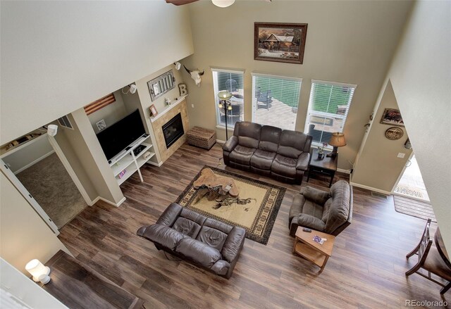 24351 E Alamo Dr, Aurora, CO 80016 - living room with a high ceiling, wood finished floors, plenty of natural light, a glass covered fireplace, and baseboards