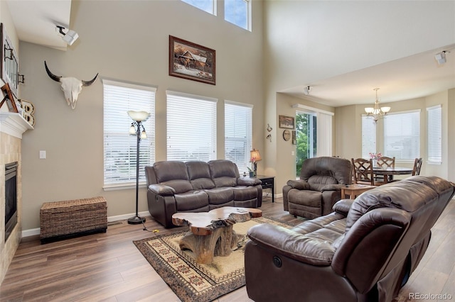 24351 E Alamo Dr, Aurora, CO 80016 - living room with a chandelier, wood finished floors, a tile fireplace, healthy amount of natural light, and a towering ceiling