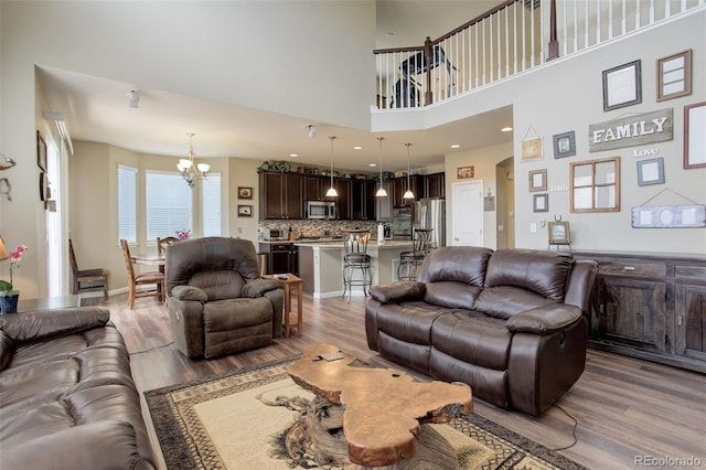 24351 E Alamo Dr, Aurora, CO 80016 - living area featuring a chandelier, wood finished floors, and arched walkways
