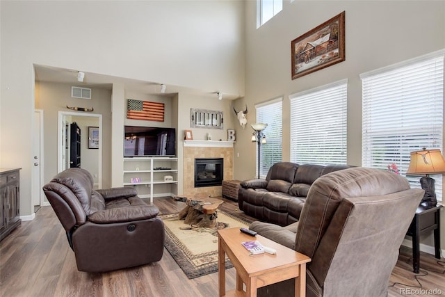 24351 E Alamo Dr, Aurora, CO 80016 - living room with a high ceiling, wood finished floors, and a tiled fireplace