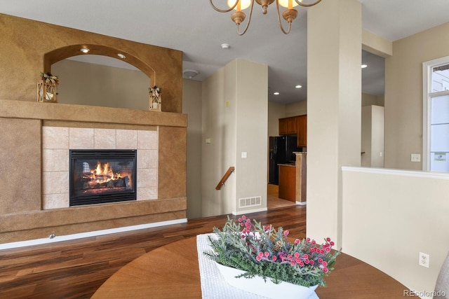 living room featuring a fireplace, a chandelier, and hardwood / wood-style floors