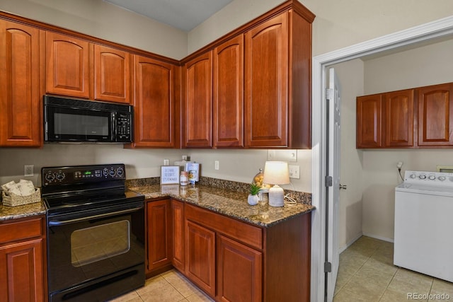 kitchen featuring dark stone countertops, washer / dryer, light tile patterned floors, and black appliances