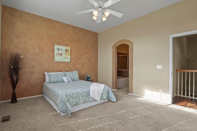 carpeted bedroom featuring ensuite bath and ceiling fan