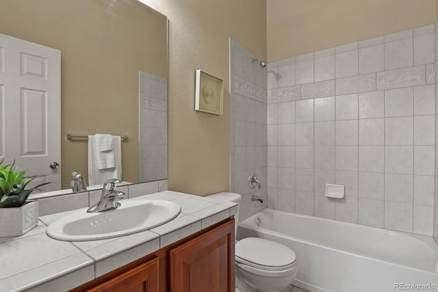 full bathroom featuring vanity, toilet, and tiled shower / bath combo