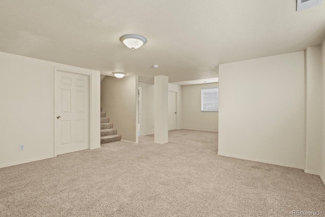 basement with light carpet and a textured ceiling