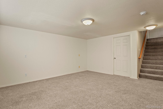 carpeted empty room with a textured ceiling