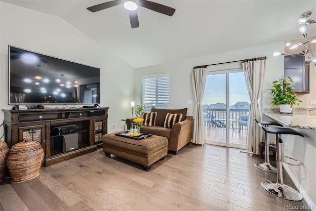 living room with lofted ceiling, ceiling fan, and light hardwood / wood-style flooring