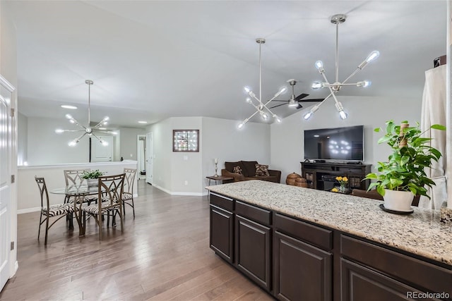 kitchen with pendant lighting, a notable chandelier, dark brown cabinets, and hardwood / wood-style floors