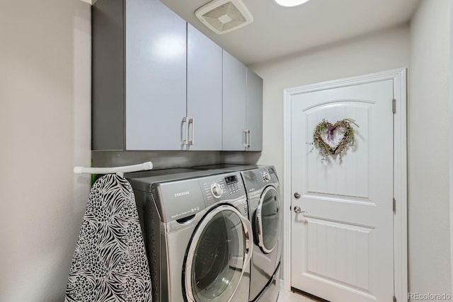 washroom with cabinets and washing machine and clothes dryer