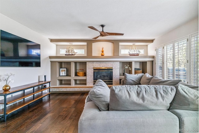 9109 Ironwood Way, Highlands Ranch, CO 80129 - living area with dark wood finished floors, a tiled fireplace, and ceiling fan with notable chandelier