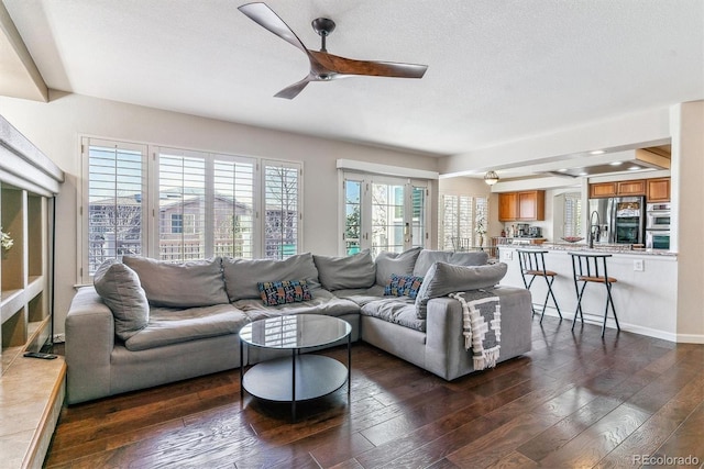 9109 Ironwood Way, Highlands Ranch, CO 80129 - living room featuring a textured ceiling, dark wood-type flooring, baseboards, and a ceiling fan