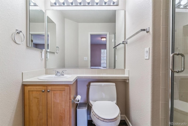 9109 Ironwood Way, Highlands Ranch, CO 80129 - bathroom with vanity, toilet, a shower stall, and a textured wall