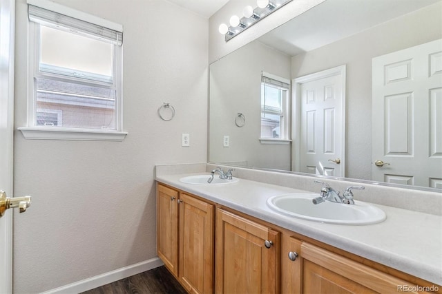 9109 Ironwood Way, Highlands Ranch, CO 80129 - bathroom with a sink, double vanity, baseboards, and wood finished floors