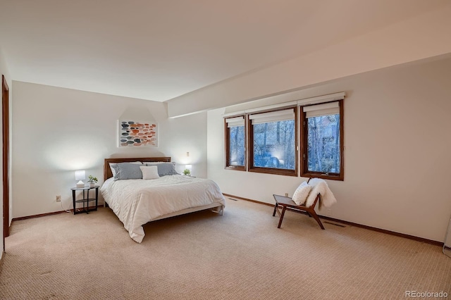 bedroom with light colored carpet and baseboards