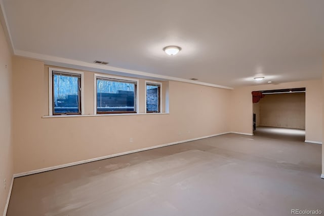spare room featuring baseboards, concrete flooring, and visible vents