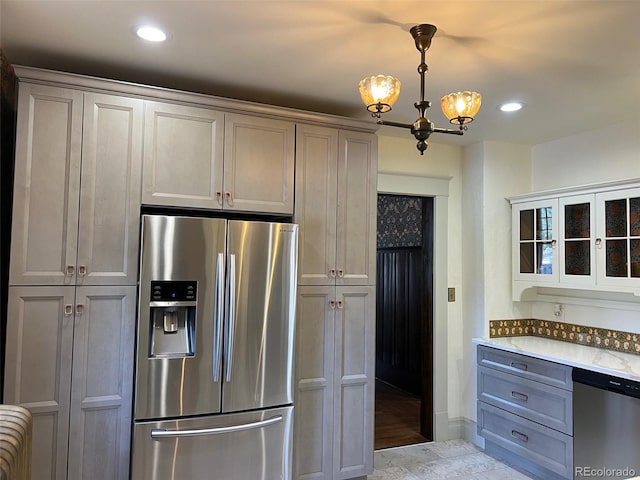 kitchen with appliances with stainless steel finishes, glass insert cabinets, gray cabinetry, recessed lighting, and pendant lighting