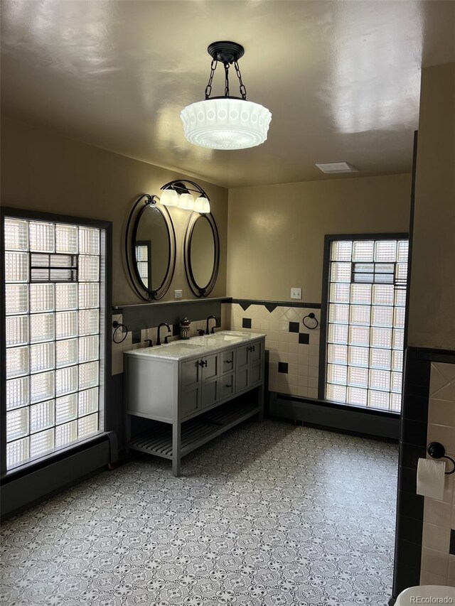 405 2nd Ave, Monte Vista, CO 81144 - bathroom with tile walls, a wainscoted wall, and vanity