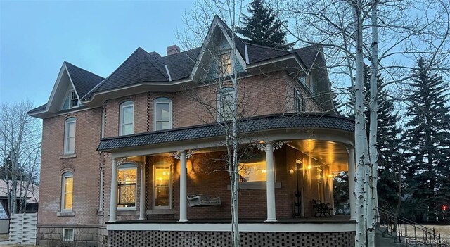 405 2nd Ave, Monte Vista, CO 81144 - rear view of house with a porch, brick siding, a chimney, and stairs