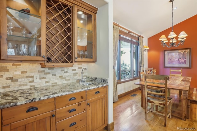 44 Canyon Ct, Eagle, CO 81631 - kitchen with a sink, decorative backsplash, light wood-style floors, a chandelier, and vaulted ceiling