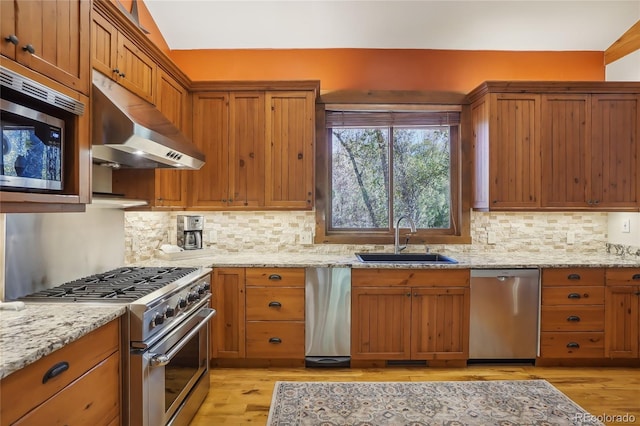 44 Canyon Ct, Eagle, CO 81631 - kitchen with stainless steel appliances, under cabinet range hood, a sink, and light wood-style flooring