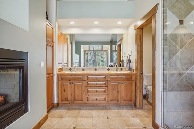 44 Canyon Ct, Eagle, CO 81631 - bathroom with toilet, double vanity, a warm lit fireplace, and recessed lighting