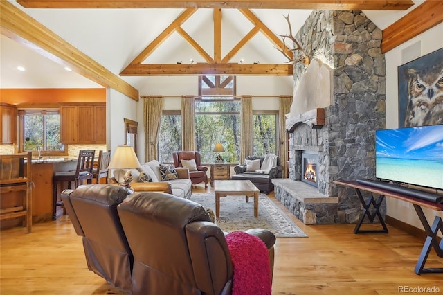 44 Canyon Ct, Eagle, CO 81631 - living area with beam ceiling, high vaulted ceiling, a fireplace, light wood-type flooring, and baseboards