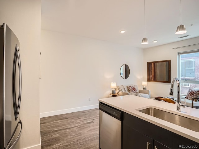 2374 S University Blvd Unit 205, Denver, CO 80210 - kitchen featuring stainless steel appliances, dark wood-type flooring, decorative light fixtures, light countertops, and recessed lighting