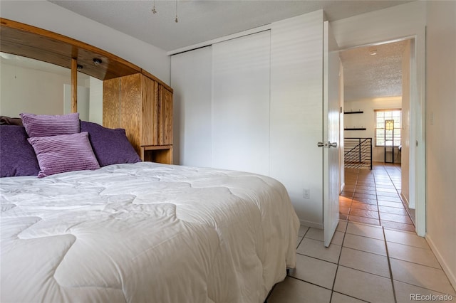 19630 E Purdue Pl, Aurora, CO 80013 - bedroom featuring light tile patterned floors, a closet, and a textured ceiling