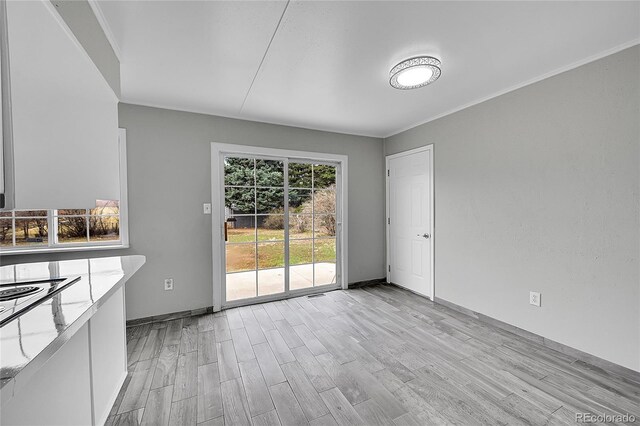2971 S Sheridan Blvd, Denver, CO 80227 - unfurnished dining area with light wood finished floors, ornamental molding, and baseboards