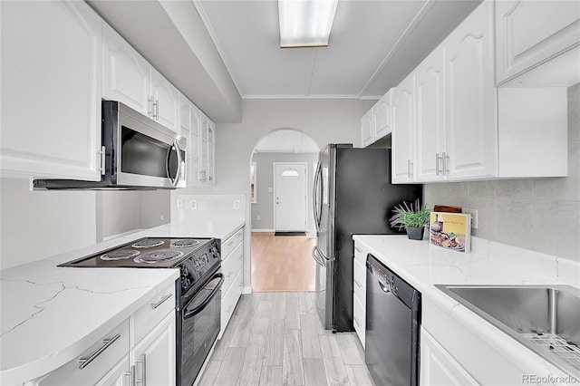 2971 S Sheridan Blvd, Denver, CO 80227 - kitchen featuring black appliances, light wood finished floors, arched walkways, and light stone countertops