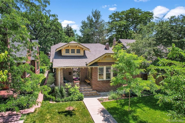 836 Steele St, Denver, CO 80206 - view of front facade featuring a front yard, a chimney, brick siding, and a shingled roof