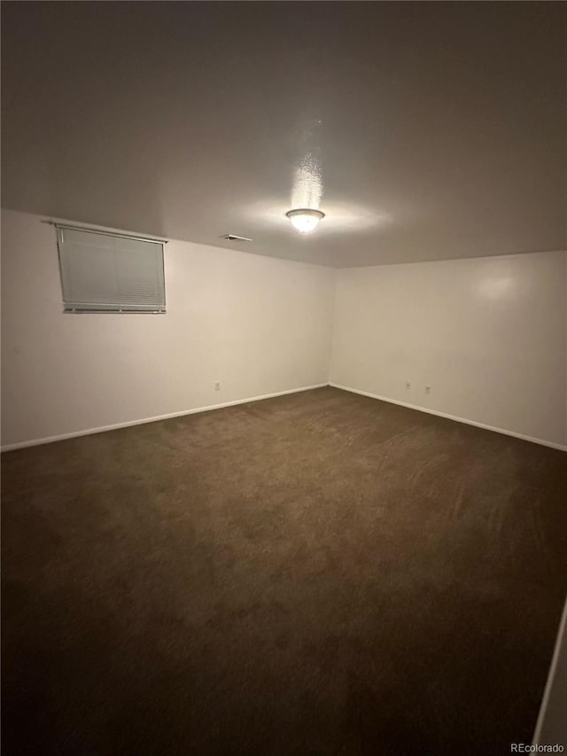 basement featuring dark carpet