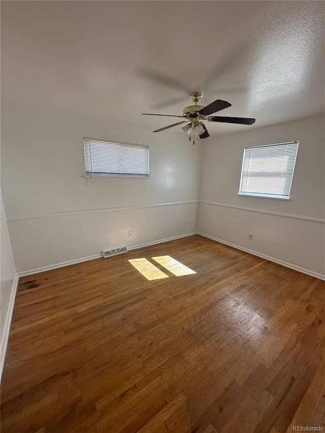 unfurnished room featuring hardwood / wood-style floors, ceiling fan, and a textured ceiling