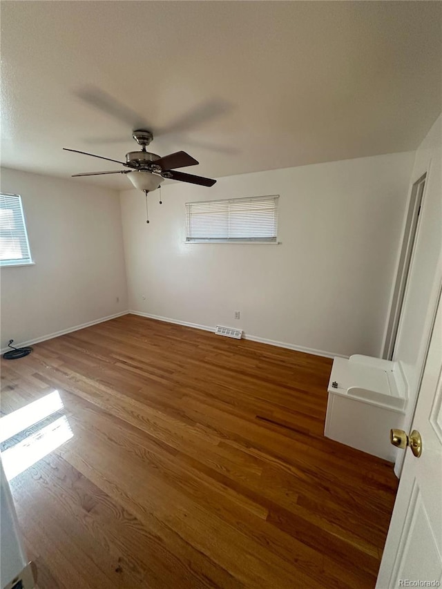 spare room with ceiling fan and dark wood-type flooring