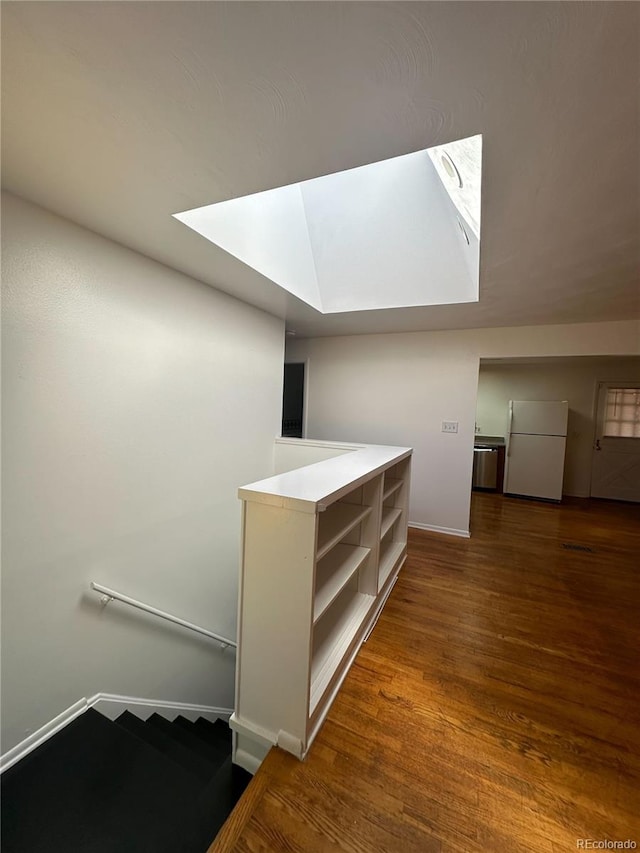 interior space featuring hardwood / wood-style floors and a skylight