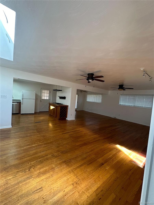 unfurnished living room with hardwood / wood-style flooring and ceiling fan