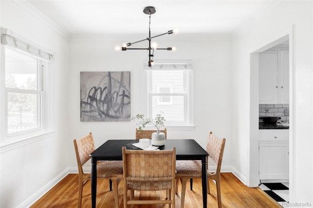 dining space with a chandelier, light wood-type flooring, plenty of natural light, and ornamental molding