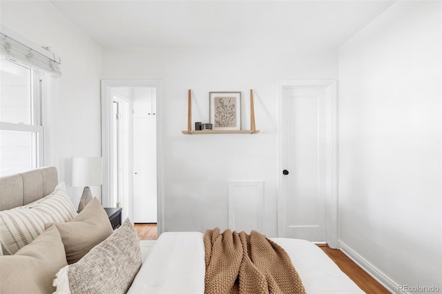bedroom with wood finished floors and baseboards