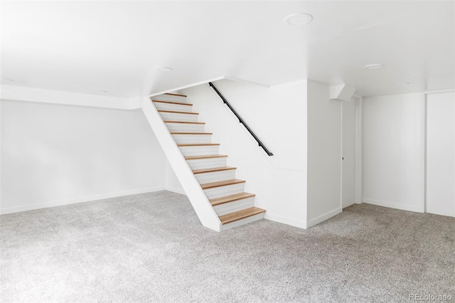 basement featuring carpet flooring, stairs, and baseboards