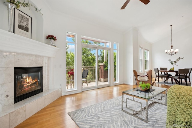 2100 N Humboldt St Unit 302, Denver, CO 80205 - living room featuring wood finished floors, a tile fireplace, ceiling fan, a chandelier, and high vaulted ceiling