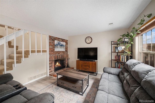 6937 S Knolls Way, Centennial, CO 80122 - living area featuring a textured ceiling, wood finished floors, stairway, a fireplace, and baseboards