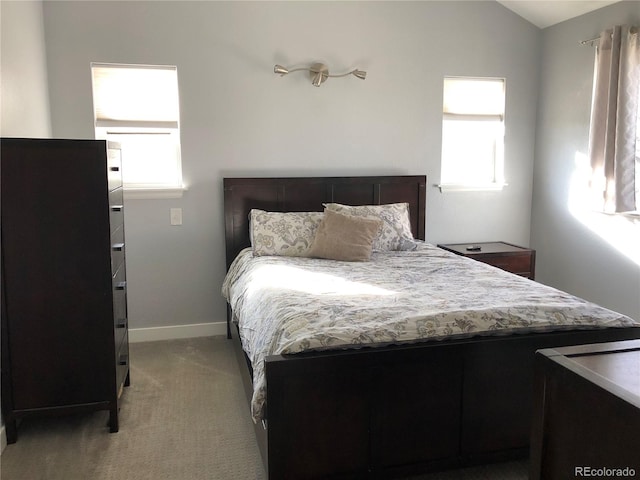 carpeted bedroom featuring vaulted ceiling and multiple windows