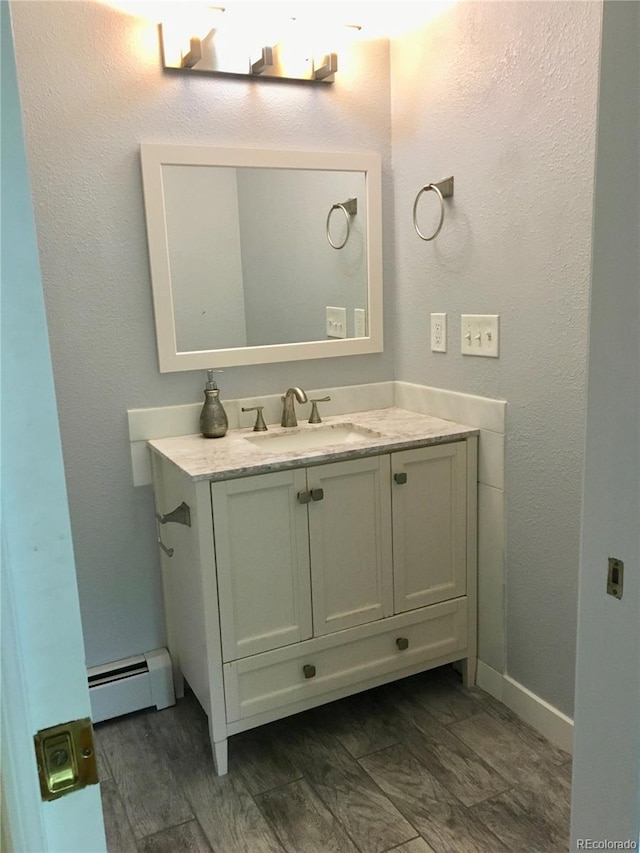 bathroom featuring a baseboard radiator, vanity, and wood-type flooring