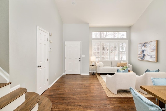 living room with dark wood-type flooring and a towering ceiling