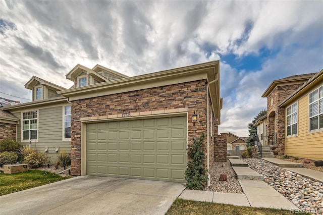 view of front of property with a garage, stone siding, and driveway