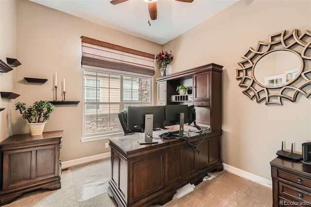 office with a ceiling fan, light carpet, and baseboards